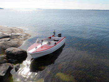 Motorboat moored in sea against sky