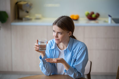 Side view of young woman drinking coffee at home