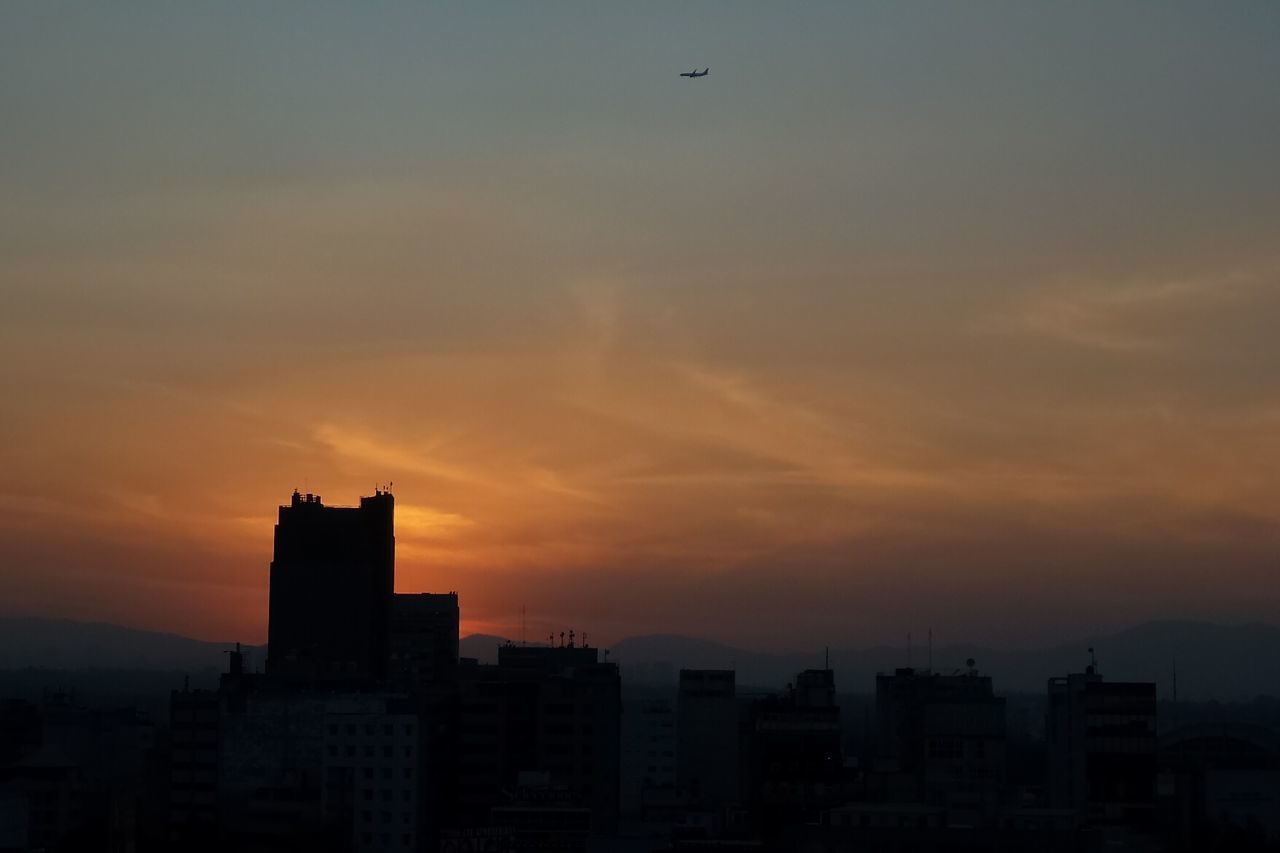 sunset, architecture, building exterior, built structure, skyscraper, city, cityscape, sky, silhouette, no people, outdoors, modern, urban skyline, nature, bird, day