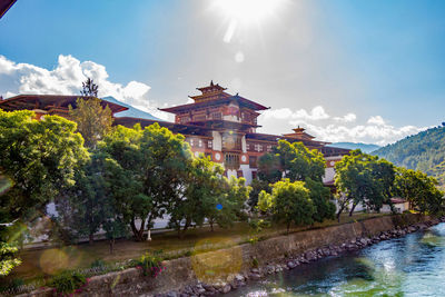 River by temples and mountains against cloudy sky