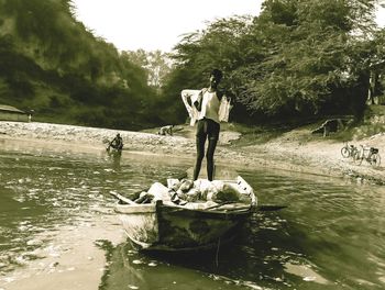 Men standing by river against sky