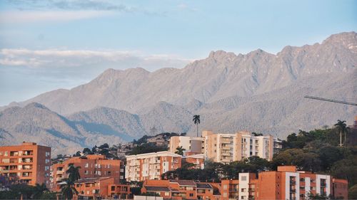 Buildings in town against rocky mountains