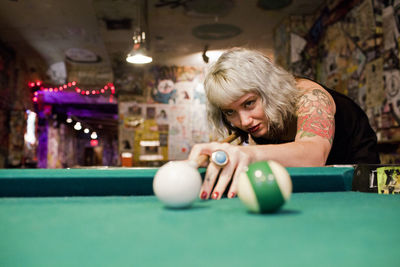 Young woman playing pool