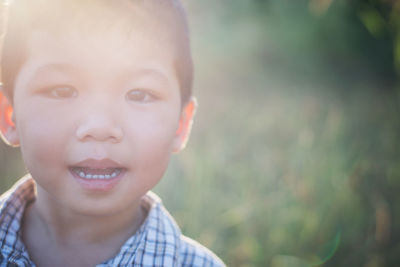 Close-up portrait of cute boy during sunny day