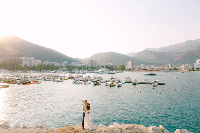 People in sea against clear sky