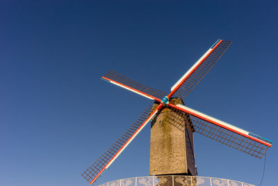 Low angle view of traditional windmill against clear blue sky