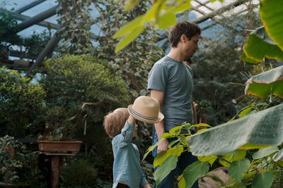 Dad and son inspecting tropical gallery in botanical garden. local travel and tourism.