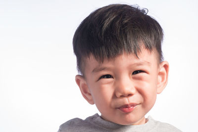 Portrait of cute boy against white background