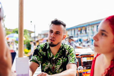 Portrait of young man looking at restaurant