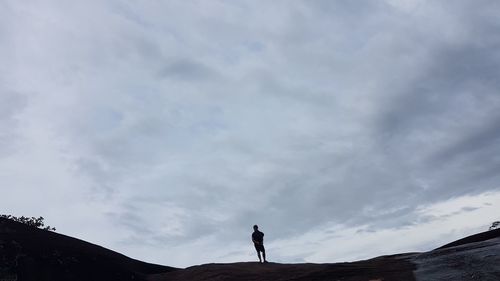 Silhouette man standing on landscape against sky