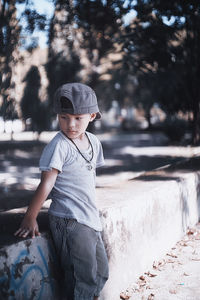 Boy standing against retaining wall at park