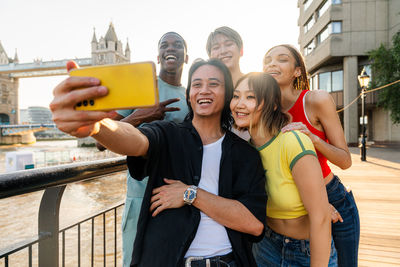 Portrait of smiling friends using digital tablet