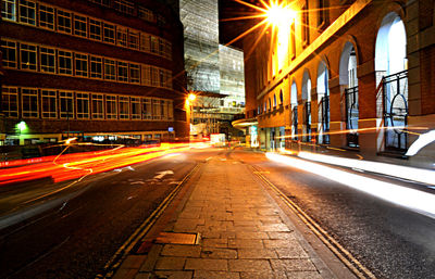 Illuminated city road against at night