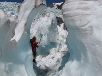 Woman standing on snow covered rock