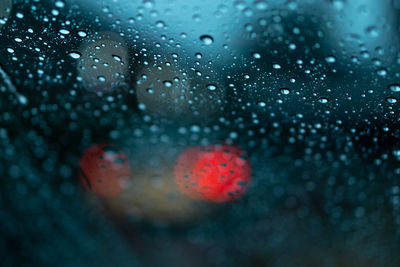 Close-up of wet glass window during rainy season