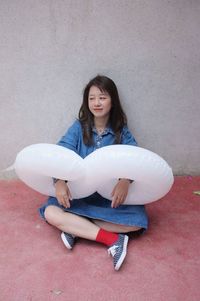 Portrait of young woman sitting on floor