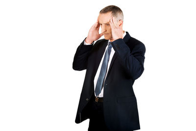 Businessman thinking while standing against white background