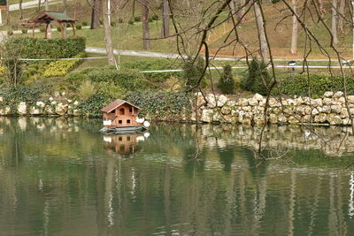 House by lake against trees