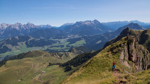 High angle view of friends standing on mountain peak