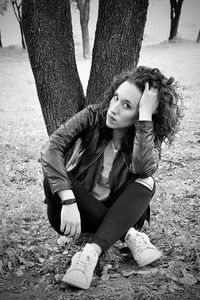 Portrait of woman sitting against trees