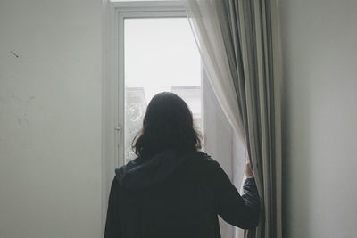 Close-up of woman looking through window