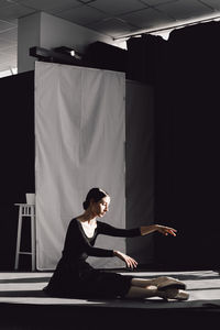 Woman looking at camera while sitting on table