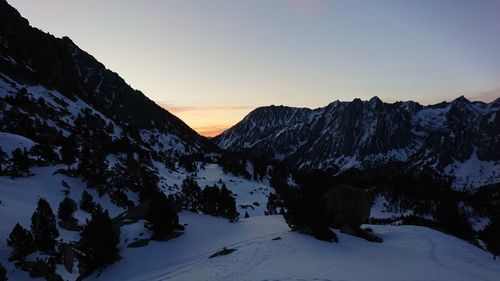 Scenic view of snow covered mountains against sky during sunset