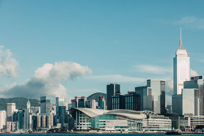 Buildings in city against cloudy sky