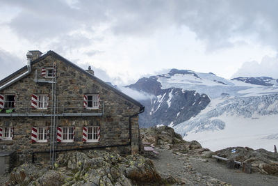 Houses on snow covered mountain against sky