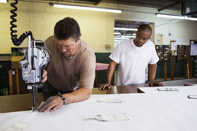 Workers using machinery in factory