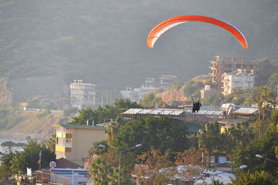 Two people in paraglider mid-air