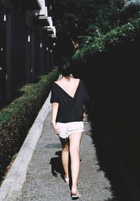 Rear view of woman walking on footpath