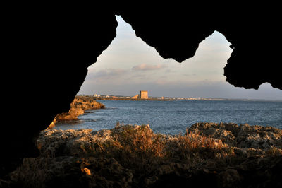 Rock formations by sea against sky