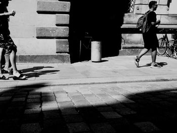 Man standing on footpath in city