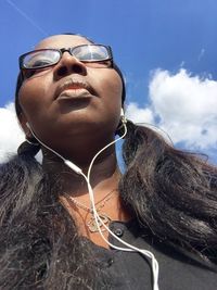 Low angle view of young woman against sky