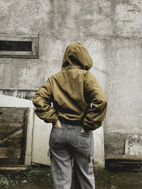 Rear view of woman standing against wall