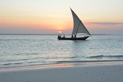 Boat sailing in sea at sunset