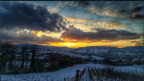 Scenic view of snow covered mountains against cloudy sky