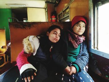 Portrait of young couple sitting in snow