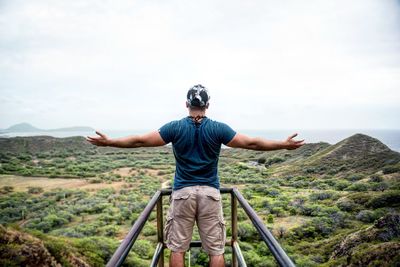 Full length of man with arms outstretched against mountain
