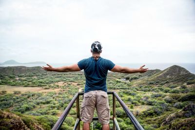 Man with arms outstretched against mountain