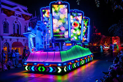 Illuminated carousel in amusement park at night