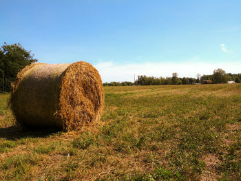 Hay bales on field against sky
