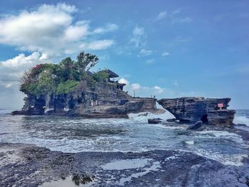 Rock formation on beach against sky