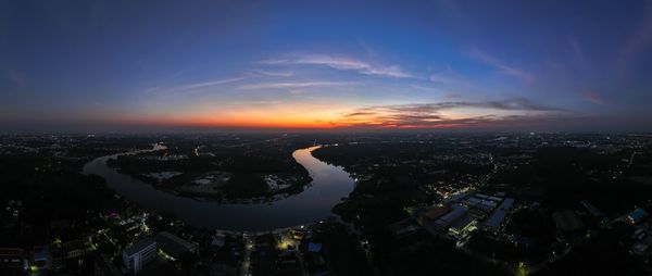 Aerial view of illuminated cityscape against sky at sunset