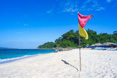 Scenic view of beach against blue sky