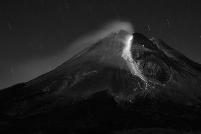 Scenic view of snowcapped mountain against sky at night