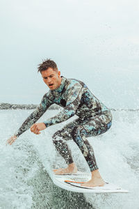 Full length of young man splashing water