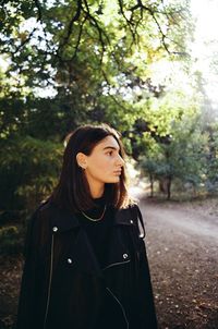 Beautiful young woman standing by tree