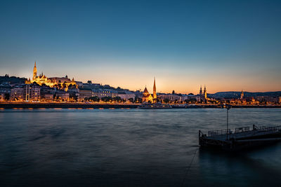 View of city at waterfront during sunset